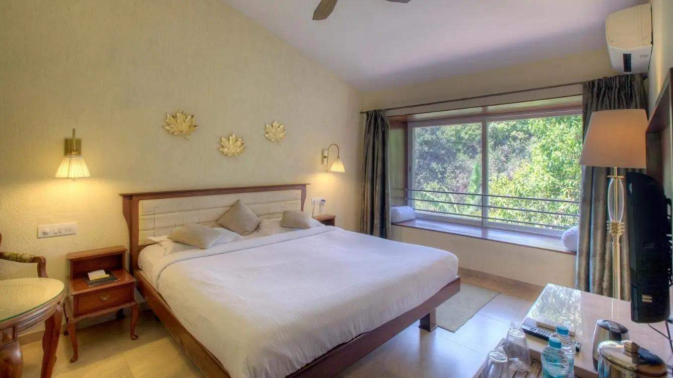 Cozy forest-view room with modern amenities and rustic decor at Ramsukh Resort in Mahabaleshwar